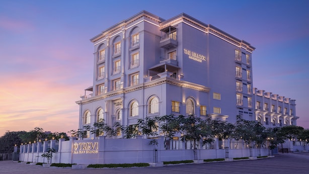 Un hotel de varios pisos con un estilo arquitectónico clásico, que cuenta con balcones y ventanas de arco.