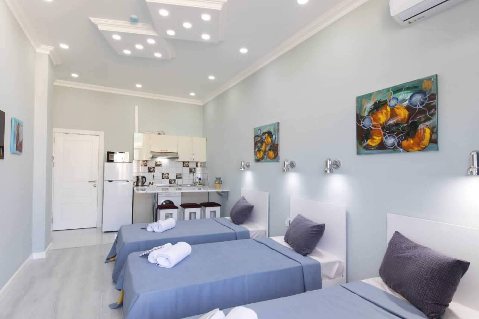 Una habitación de hotel con dos camas, kitchenette y baño.
