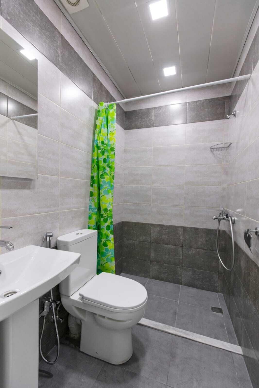 A modern bathroom with a toilet, sink, and shower area.
