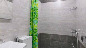 A modern bathroom with a toilet, sink, and shower area.
