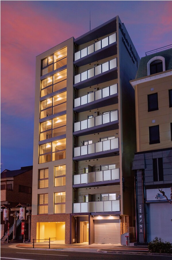 A multi-story hotel with a modern design, featuring a ground-level entrance and multiple balconies. - Shinkou House UE (Osaka)