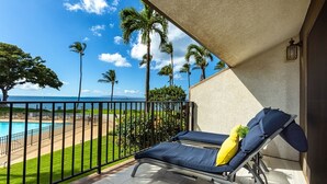A balcony with a pool view, lounge chairs, and a clear sky. - Maalaea Surf G8 2 Bedroom Condo (Kihei)
