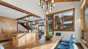 Una cocina amplia con armarios de madera, una isla central y sillas azules.