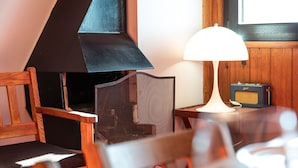 Et hyggeligt værelse med pejs, lampe og et vintage radioapparat.