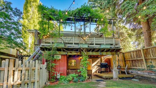 A backyard with a wooden deck, a barbecue area, and a covered seating area. - Lovely Salt Lake City Cottage w/ Outdoor Space! (Salt Lake City)