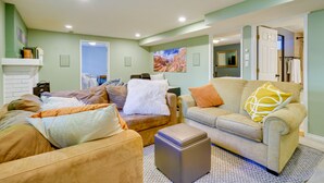 A living room with two sofas, a coffee table, and a fireplace. There is a door leading to a bathroom. - Lovely Salt Lake City Cottage w/ Outdoor Space! (Salt Lake City)