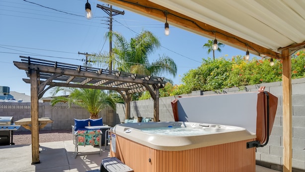 Ein hölzernes Whirlpool unter einer Pergola mit Tisch und Stühlen in der Nähe.