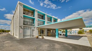 A multi-story building with a flat roof and a covered entrance area.