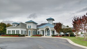 A large, two-story building with a central entrance, large windows, and a blue roof. - 6 Mi to Rehoboth Beach: Townhome w/ Pool Access! (Rehoboth Beach)