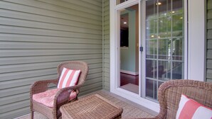 A covered porch with wicker furniture and a sliding glass door. - 6 Mi to Rehoboth Beach: Townhome w/ Pool Access! (Rehoboth Beach)