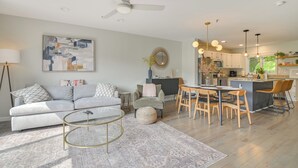 A modern living room with a sofa, coffee table, and a dining area with chairs and a table. - North Conway Home for Fall Adventures (North Conway)