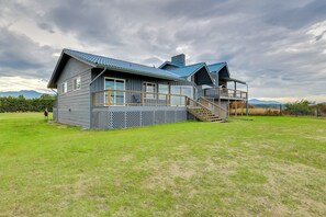 A modern house with a large deck, a staircase, and a view of mountains. - Oceanfront Port Angeles Home w/ Mountain View! (Port Angeles)