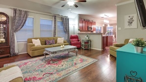 A living room with a sofa, coffee table, and a patterned rug. - Patio, Pergola & Pool Access: Aubrey Retreat! (Aubrey)