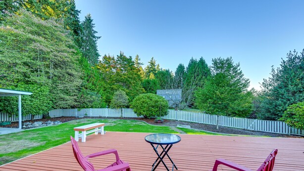 A wooden deck with two red chairs and a small table. - Enchanting Puyallup Home w/ Spacious Deck! (Puyallup)