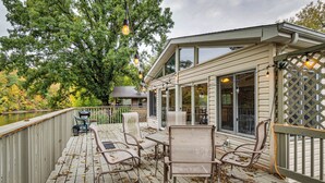 A wooden deck with outdoor furniture, a covered seating area, and a view of a lake. - Riverfront Brookston Retreat w/ Deck & River Tubes (Brookston)