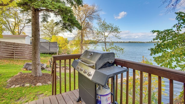 Una griglia da barbecue su un pontile di legno con vista sul lago.