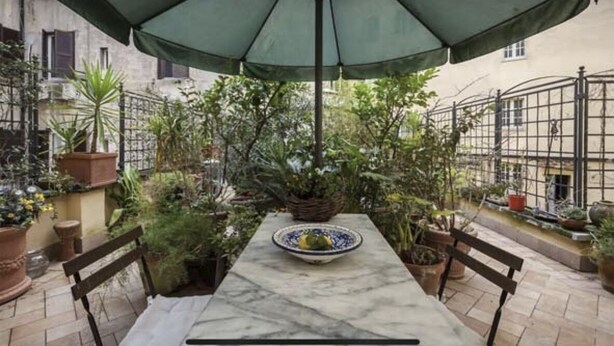 A patio with a table, chairs, and a large umbrella. - Vacances Romaines (Roma)