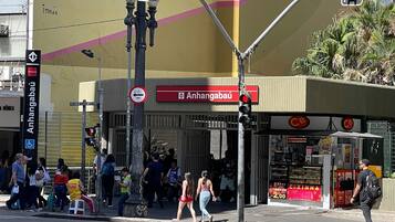 A street scene with a traffic light, pedestrians, and a building with a CB logo.