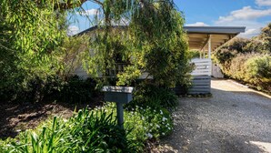 A modern building with a gravel driveway and a wooden fence.