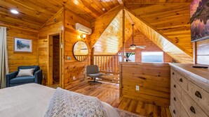 A cozy cabin room with a bed, a chair, a dresser, and a ceiling fan. - Top of the Smoky Mountain Views, Hot Tub + 10ft Projector (Sevierville)