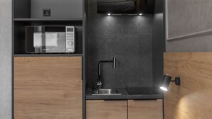 A modern kitchen with a built-in microwave, a sink with a faucet, and wooden cabinets. - Jam Apartments (Lviv)