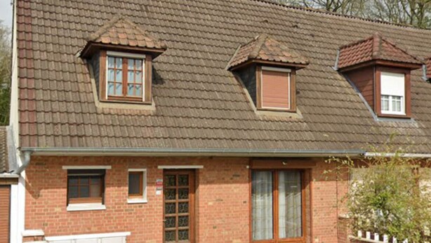 A two-story brick house with a sloped roof, a front door, and a small porch area. - Maison avec piscine proche des plages (Friville-Escarbotin)
