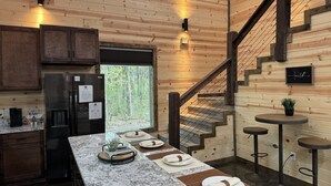 A modern kitchen with wooden walls, a marble countertop, a built-in refrigerator, and a wooden staircase. - The Beautiful Moonlight Dream Cabin in Broken Bow is STUNNING! (Broken Bow)