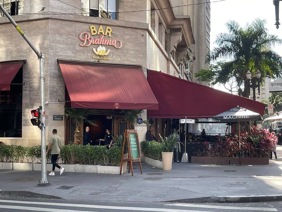 A bar named 'BAR Brahma' with a red awning, outdoor seating, and a signboard.