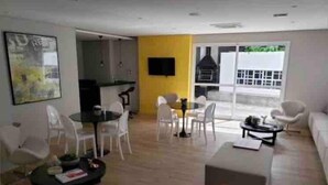 A modern living room with a dining area, a kitchen, and a balcony with a view. - Luz 1109 (São Paulo)