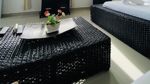 Une chambre d’hôtel avec un lit, une commode, une télévision et une fenêtre avec des rideaux.