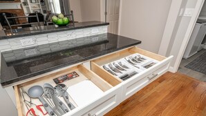 A kitchen with a black countertop, white cabinets, and a wooden floor. - Cozy and Close to Kings Island (Kings Mills)