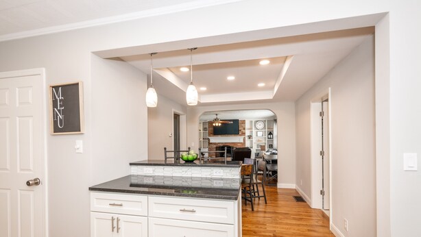 A modern kitchen with white cabinetry, a black countertop, and pendant lighting. - Cozy and Close to Kings Island (Kings Mills)