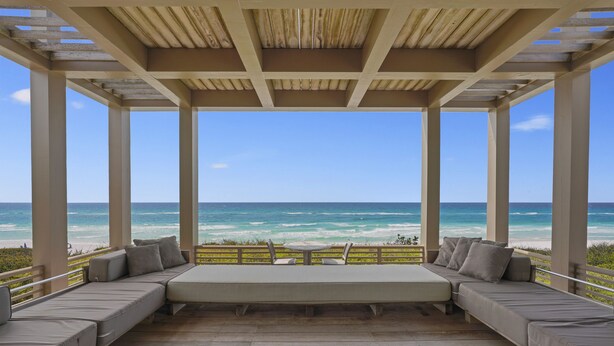 A covered outdoor seating area with a view of the ocean.