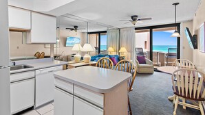 A modern hotel room with a kitchen, dining area, and a view of the ocean. - Sunrise gulf view/beach front condo! Enjoy one free beach chair set up each day (Destin)