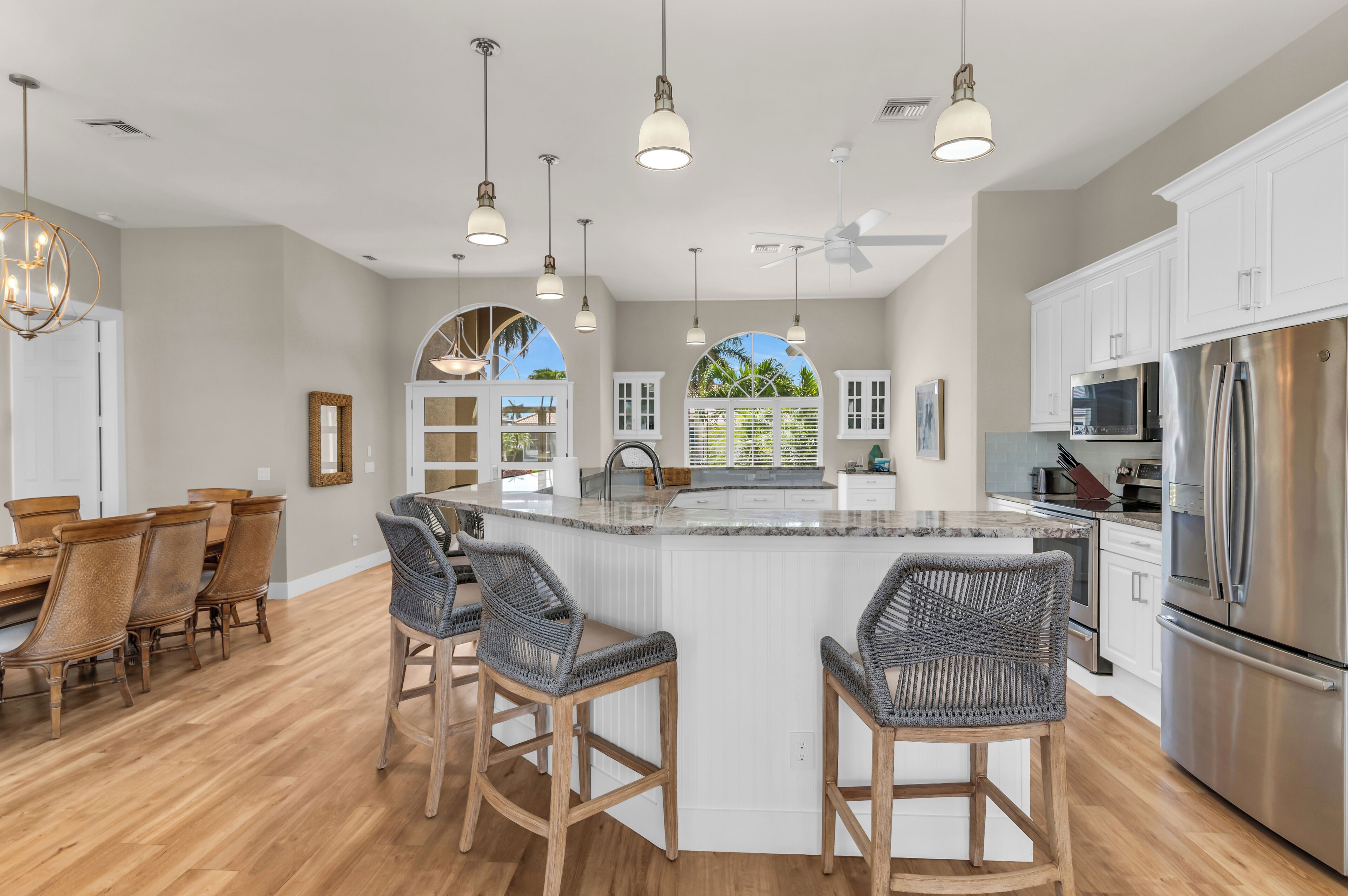 A spacious kitchen with a central island, bar stools, and modern appliances.
