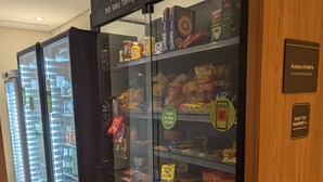 A refrigerated display case with various food items and beverages, including snacks, drinks, and condiments. - Sunflower Stays (São Paulo)