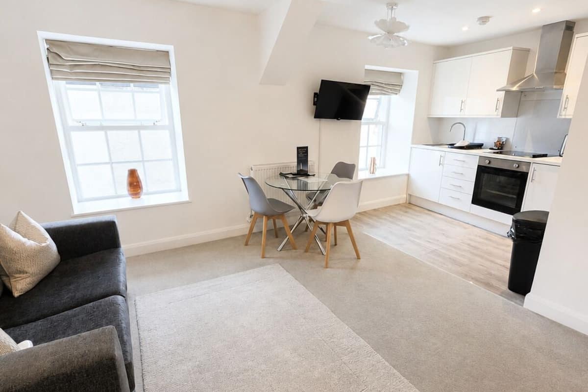 Un appartement moderne comprenant un coin repas, une cuisine et un salon.