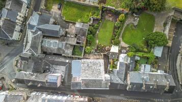 Vista aérea de un pueblo histórico con calles estrechas, edificios tradicionales y una combinación de viviendas y locales comerciales.