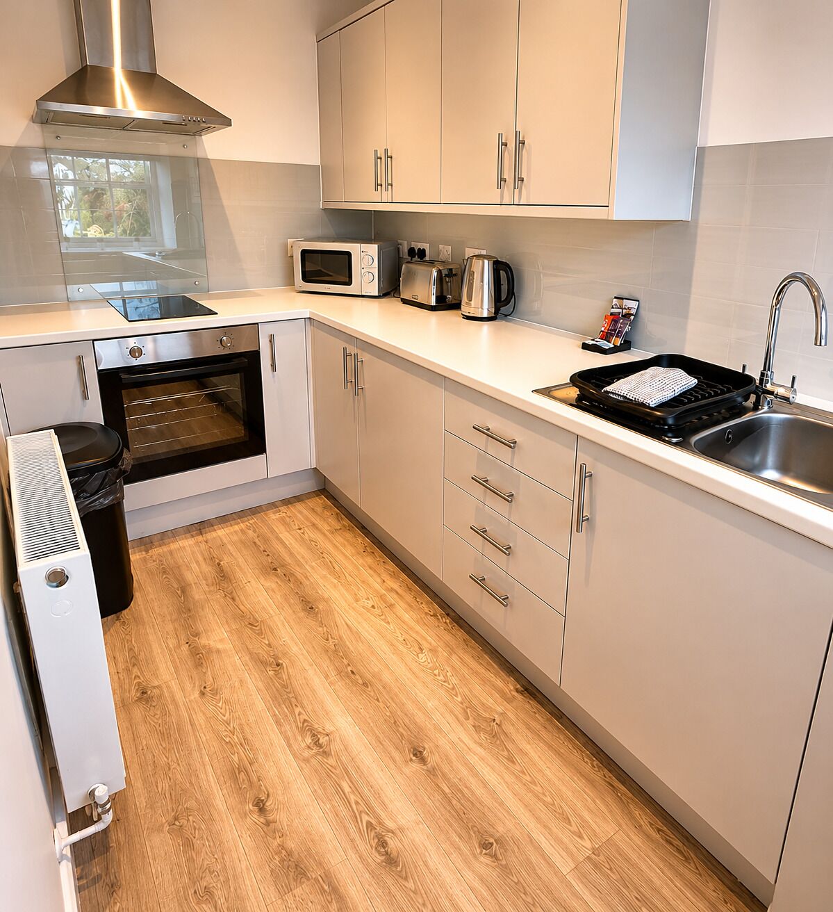Eine moderne Küche mit Backofen, Mikrowelle, Toaster und Spüle.