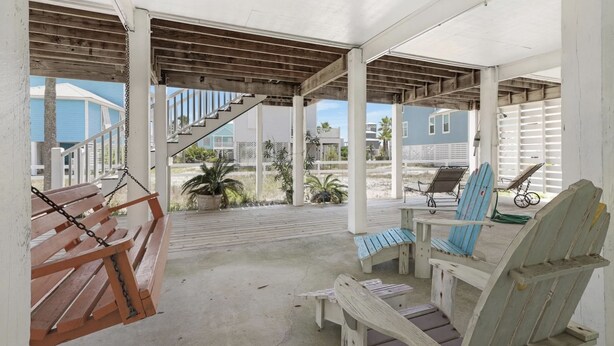 A covered outdoor area with a wooden bench, a chair, and a table. - Super Cute!   Easy Beach & Pool Access (Gulf Shores)