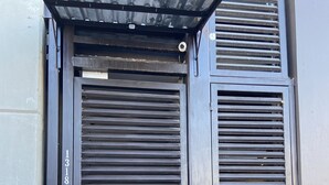 A closed metal door with a keypad lock and a small window above it. - AB Bed and breakfast  (Chihuahua)