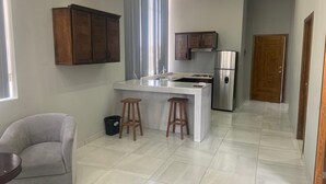 A modern kitchen with a central island, stainless steel appliances, and wooden cabinets. - AB Bed and breakfast  (Chihuahua)