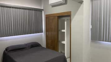 Ein Schlafzimmer mit Bett, Kleiderschrank und Klimaanlage.
