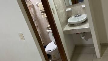 Een badkamer met toilet, wastafel en spiegel.
