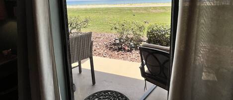 A view from inside a room with a window overlooking a grassy area and a clear sky.