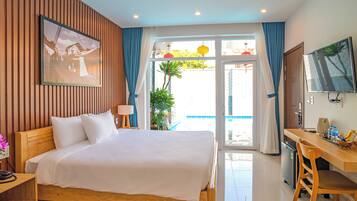 Une chambre d’hôtel avec un lit, un bureau, une télévision et une vue sur l’extérieur.