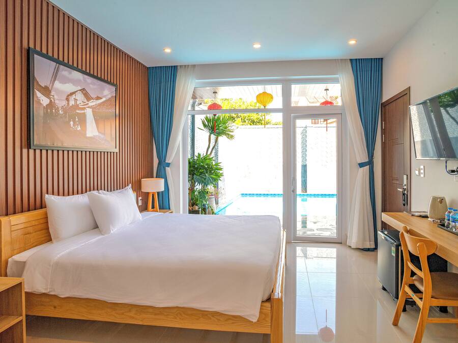 Une chambre d’hôtel avec un lit, un bureau, une télévision et une vue sur l’extérieur.