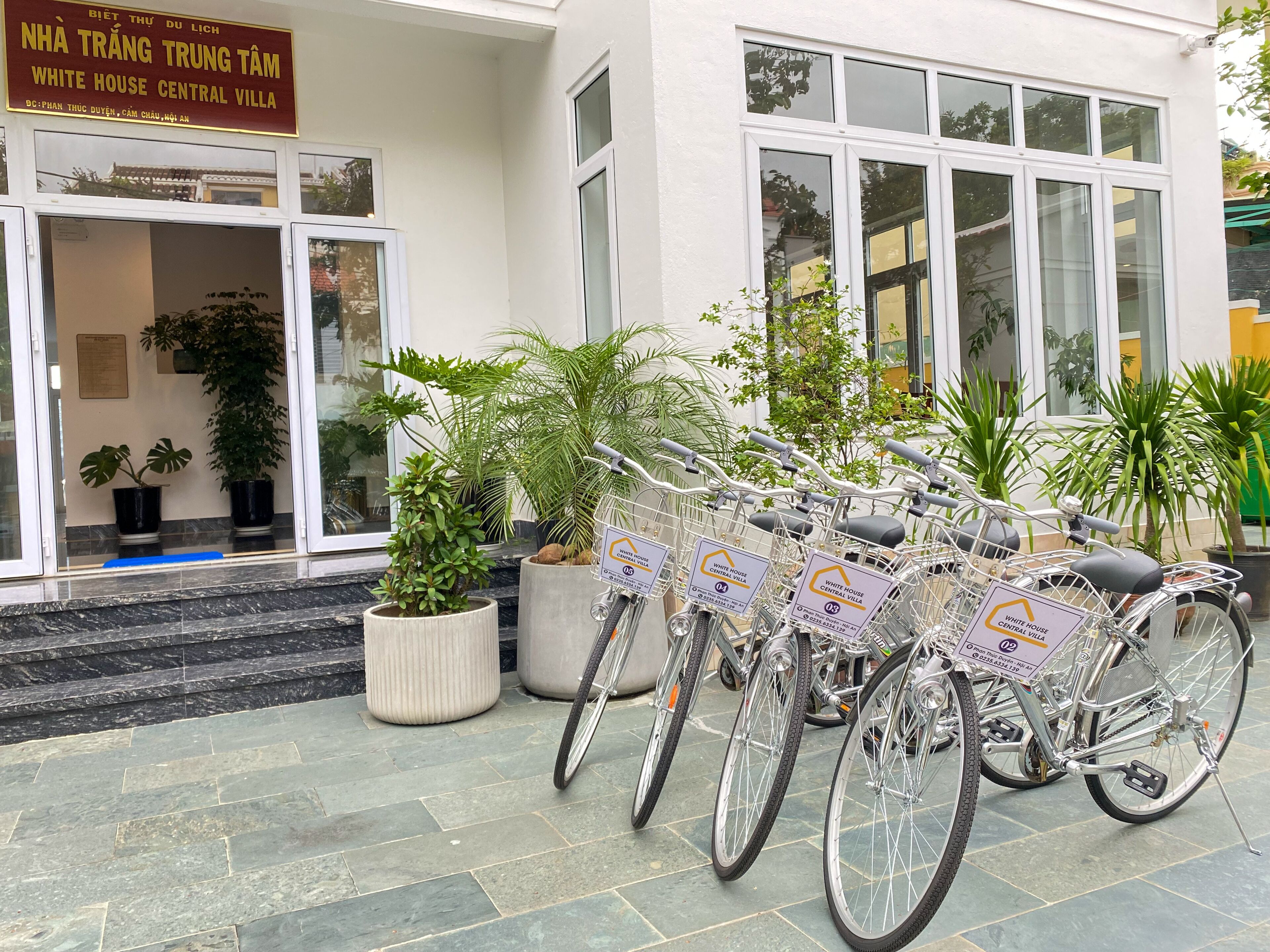 A building entrance with a sign reading "White House Central Villa" and several bicycles parked outside.