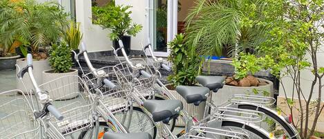 Una hilera de bicicletas estacionadas frente a un edificio con un letrero que dice 'NHA TRANG TRUNG TAM WHITE HOUSE CENTRAL VILLA'.