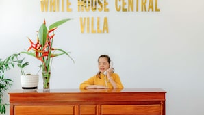 En receptionsdisk med et skilt, der står "WHITE HOUSE CENTRAL VILLA".